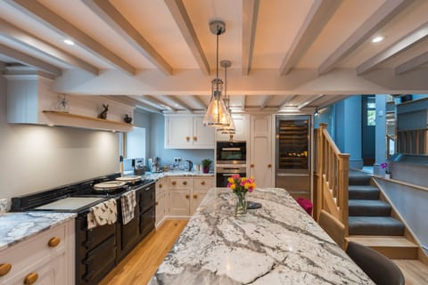 kitchen with stairs leading up to the snug, downstairs toilet and boot room.
