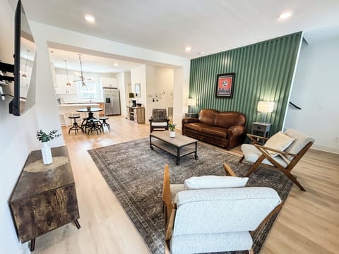 LIVING ROOM– This spacious and open living area seamlessly connects to the dining and kitchen spaces, creating a welcoming environment perfect for relaxation or entertaining. The comfortable seating arrangement, complete with a cozy leather sofa and stylish accent chairs, faces a mounted 52" flat-screen TV for a perfect movie night or catching up on your favorite shows. The sof...