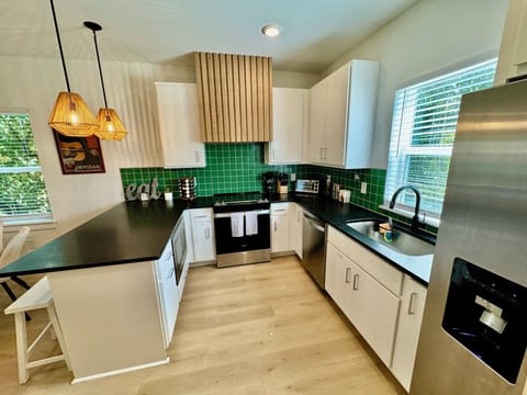 KITCHEN - Bright and modern, this fully-equipped kitchen is designed with an open concept, seamlessly flowing into the dining and living areas. Perfect for cooking and entertaining, the kitchen features sleek countertops, stainless steel appliances, and ample storage space. The open layout allows you to stay connected with family and friends in the dining or living area while p...