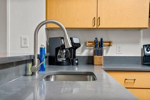 Modern kitchen sink area with stainless steel faucet and coffee maker