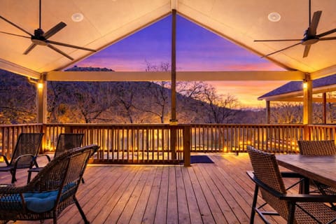 Relax on the spacious covered deck overlooking the Guadalupe River, complete with ceiling fans and cozy seating.