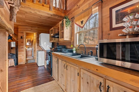 Cabin kitchen with wood cabinets, a functional and rustic cooking space.
