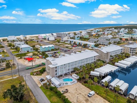 Waterfront vacation rental complex featuring pool amenities and marina access in a coastal community setting.