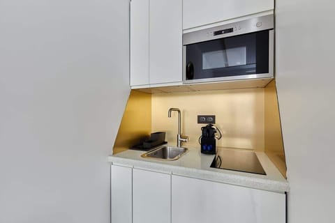 kitchnette avec micro onde, machine à café, plaque de cuisson, frigo