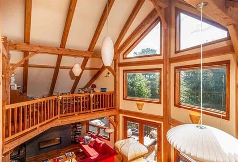 An open post and beam great room with panoramic views of green mountains