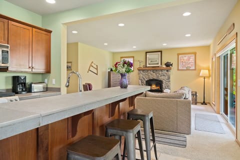 Fully equipped kitchen open to the dining room and living room with fireplace, TV, large cozy couch, access to back yard with firepit.