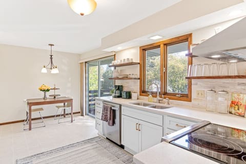 Modern meets charm in this remodeled kitchen featuring stainless steel appliances, sleek quartz countertops, & open farmhouse shelving. Enjoy meals in the cozy breakfast nook or step out onto the deck for fresh air!