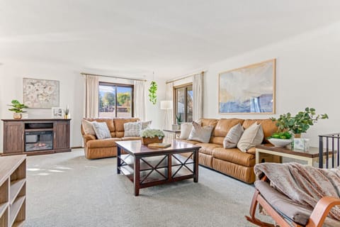 Step into this sun-drenched living room at Minne-Getaway: Kraft Gallery, creating a warm & inviting ambiance. The cozy sofa and loveseat provide the perfect spots to relax, unwind, and enjoy the comfort of home.