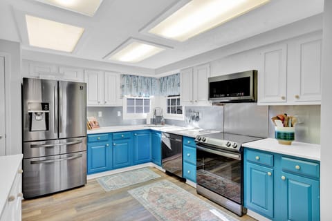 Fully stocked kitchen with stainless steel appliances.