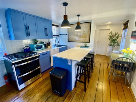 Fully renovated kitchen with wide plank, pine floors, and quartzite countertops.