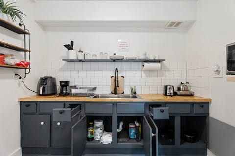 Thoughtful touches like dishware, utensils, paper towels, and a drying rack make this space functional and guest-ready.