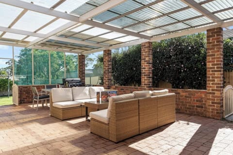 Sheltered outdoor area with outdoor dining table, comfortable outdoor seating and BBQ. Ideal for entertaining!