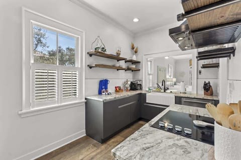 Euro chic kitchen with farmhouse sink open to living and dining areas