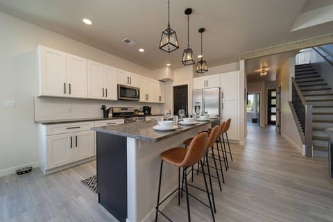 A modern kitchen with crisp white cabinetry and elegant pendant lighting, offering the perfect blend of style and functionality for both cooking and socializing