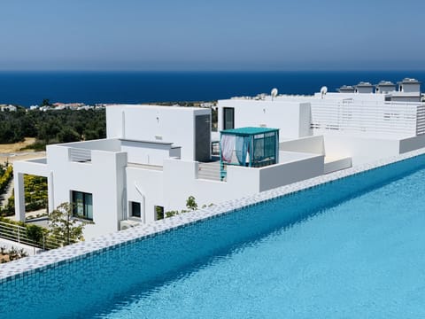 Blick vom Infinity Pool auf das Bungalowapartement mit Dachterrasse