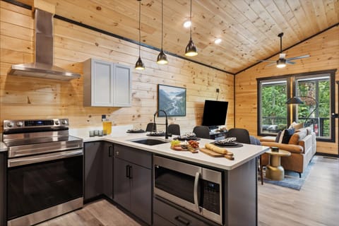 Move on inside and be blessed with everything you need for a comforting stay, with a cozy cabin feel intertwined with modern spark such as the stunning kitchen area with everything you need to cook up your meals each night