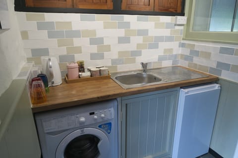Laundry/kitchenette with fridge in external utility/games area, next to sunroom
