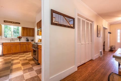 Kiitchen and hallway with downstairs powder room to the left.