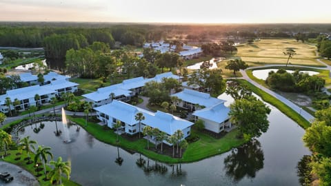 An aerial view of serene lakeside lodgings framed by fairways and Florida sunshine.
