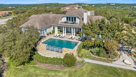 Soar above your private Hill Country retreat—an expansive estate unfolding below with the glittering infinity pool, sun-soaked patio, and secluded serenity all your own.