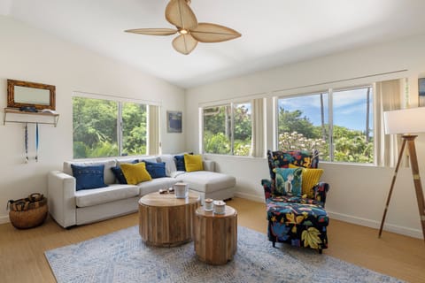 Unwind in your bright living space with tropical garden views and stylish coastal decor that perfectly frames relaxation.