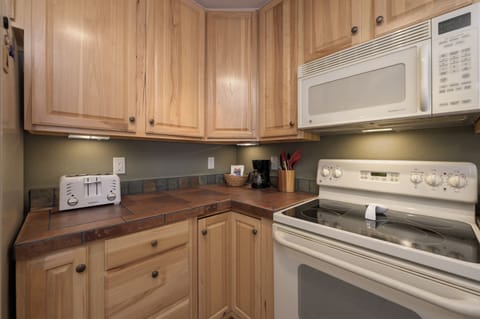 Your fully equipped kitchen awaits with warm wood cabinets, full-size appliances, and everything you need to prepare meals during your stay.