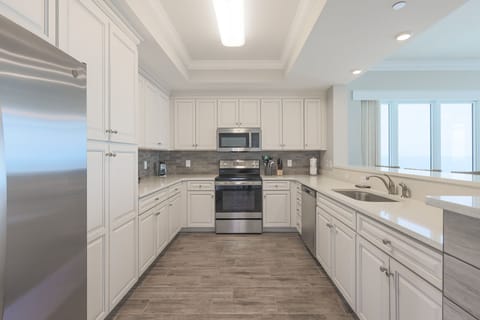 Prepare meals in this kitchen with elegant cabinetry, stainless appliances, and spacious countertops
