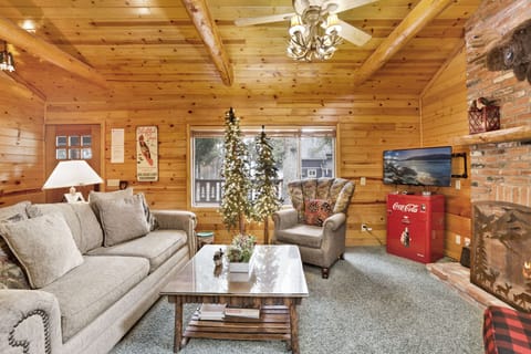 Spacious living room with glowing fireplace, cozy seating, and soft lighting creating a warm retreat.