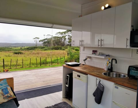Kitchenette with 6m stacker slider doors + ocean, country + golf course views.