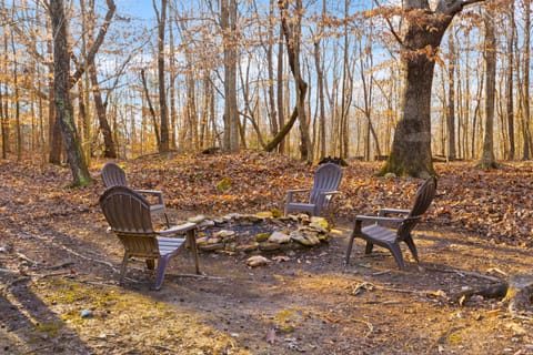 Rustic fire pit surrounded by forest, offering a perfect spot for evening gatherings 