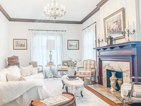 Living room adorned with plush furnishings and exquisite artwork. Natural Sun.