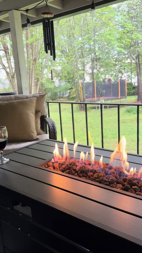 Propane fire with view of wooded backyard and trampoline