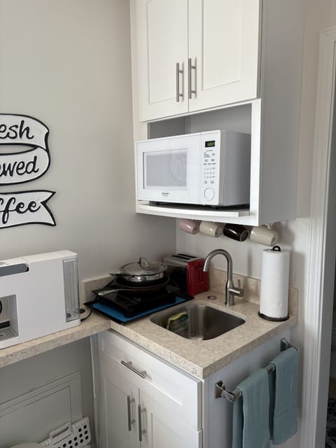 Mini kitchenette has induction burner, coffee maker, tea hot pot, toaster, sink