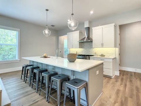 Our open kitchen with a sizable island, dining area, and breakfast bar is designed for both gourmet cooking and casual dining