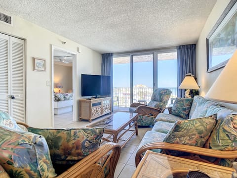 Comfortable seating with tropical accents and large windows showcasing stunning views.