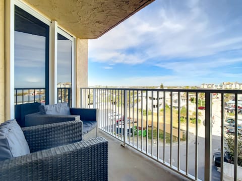 Cozy balcony seating offering scenic views of the neighborhood and sky.