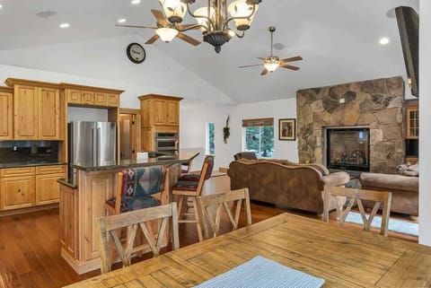 The view from the dining table towards the living room and the beautiful stone accent wall that surrounds the gas fireplace.