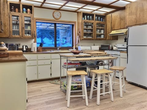 Spacious kitchen, fully stocked, island rack  to stash pantry items. 