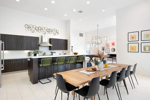 Dining area and kitchen, with the game room accessible behind.