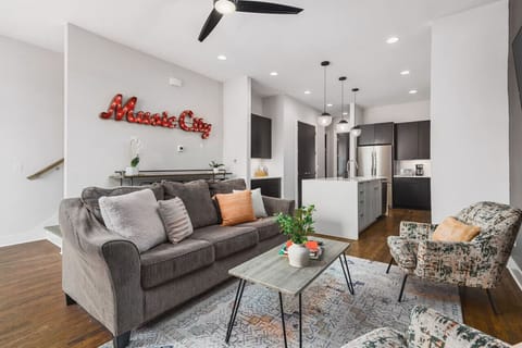 Comfortable living room with a Smart TV, ceiling fan, and plenty of seating for a game or movie night at home.