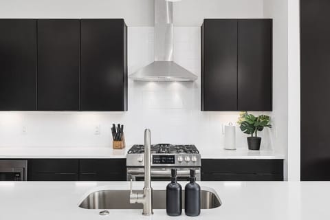 Fully-stocked chef's kitchen with a gas range, wet bar, seating for four at the island, and all the appliances / tools you could need to cook and enjoy a meal together.