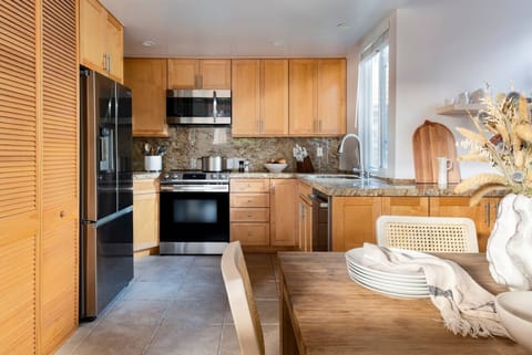 The kitchen has attractive granite countertops, modern stainless steel appliances, and a dedicated area for making coffee. All of the appliances, including the washer and dryer in the closet, are brand new and were installed in 2023.