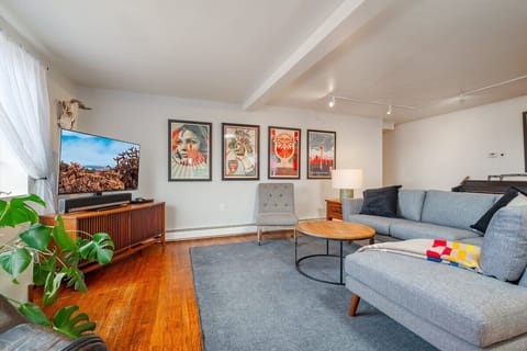 Living room with ample seating, cool artwork and a large flat screen TV