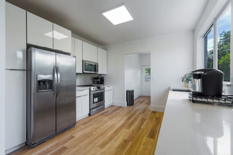 Gourmet chef's kitchen with all-black cabinetry and waterfall counters.