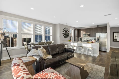 Bright open floor living space featuring a smart flat-screen TV, designer furnishings, and dining room table.