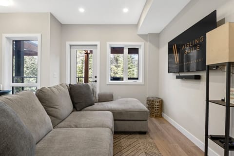 Living room with a 55` Roku/Smart TV, cozy couch, a dedicated workstation and access to the private hot tub.