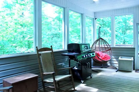 Relax on the upper screened porch, home to the grill and swinging hammock chair.