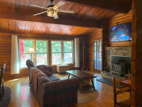 Open concept living room with wood burning fireplace and TV with ROKU.