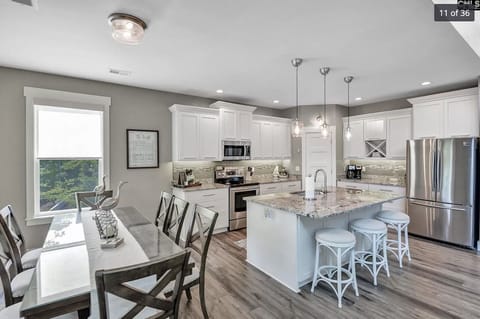 Upstairs kitchen with seating at the island and large dining table.  