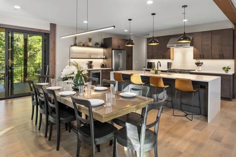 Stylish kitchen and dining space with seating for 12, premium appliances, and open shelving.